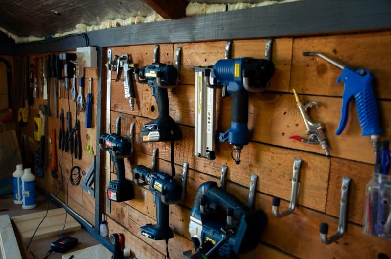 Hand and power tools organized on a workshop wall